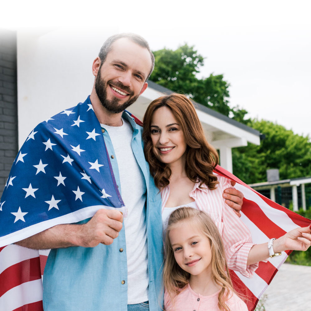 happy kid near cheerful parents with american flag standing near house